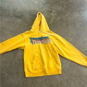 adult Small yellow Disneyland hoodie with rainbow lettering across the top